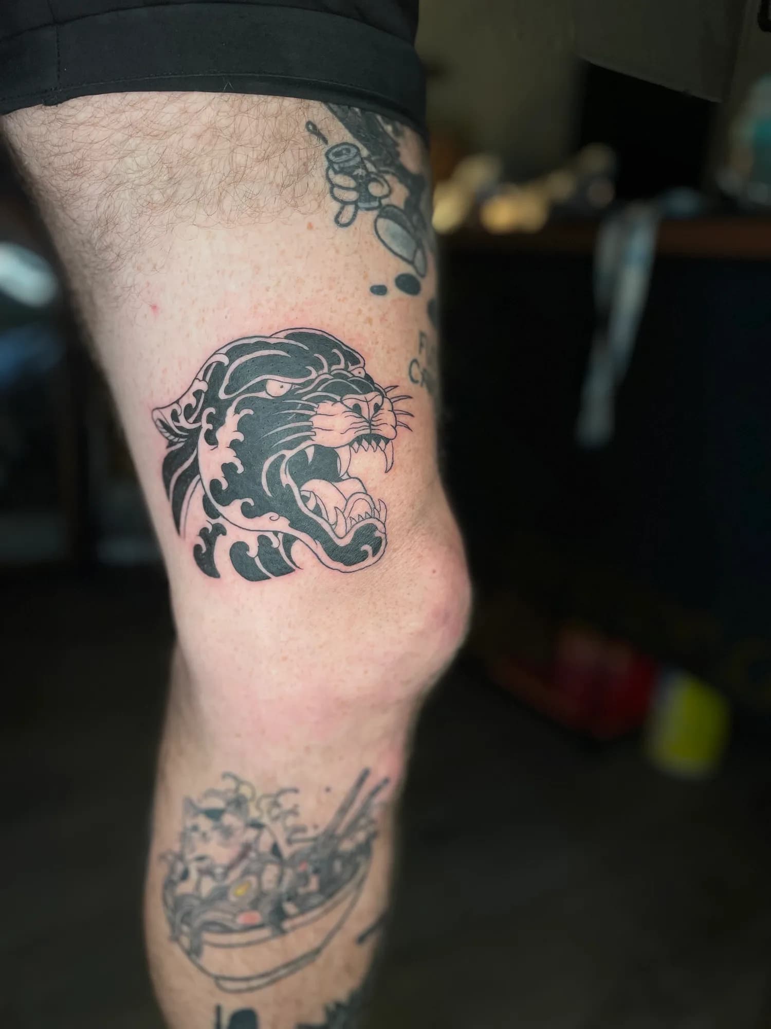 Black and grey new school traditional panther and wave inner thigh tattoo by Kamy Cao.