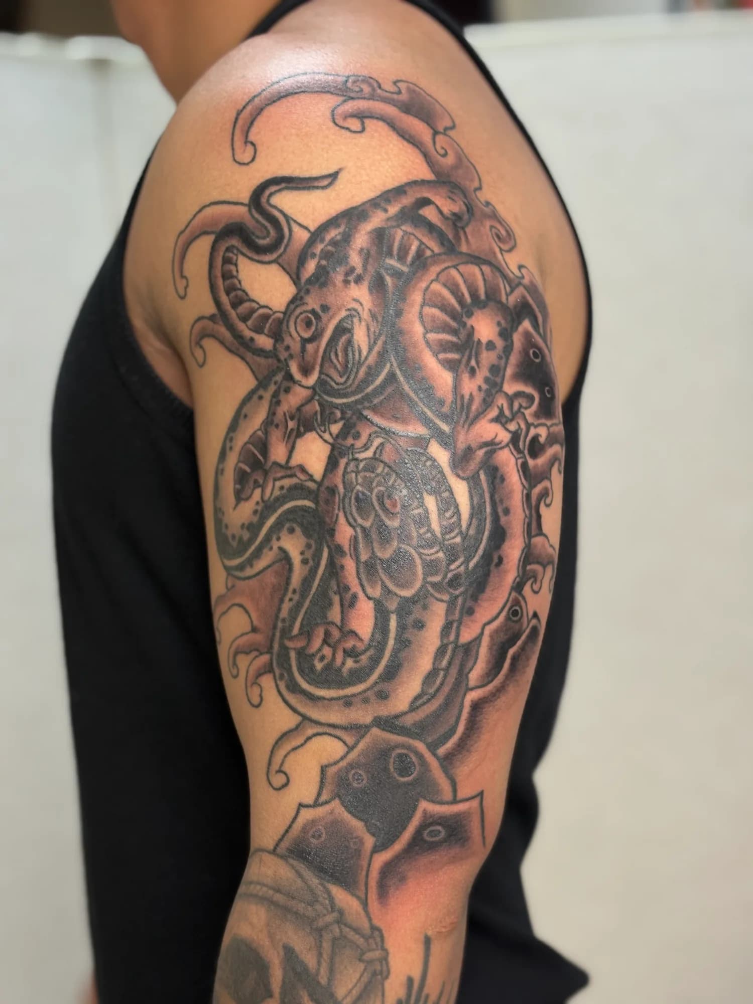 Black and grey new school Japanese snake vs frog shoulder tattoo by Kamy Cao.